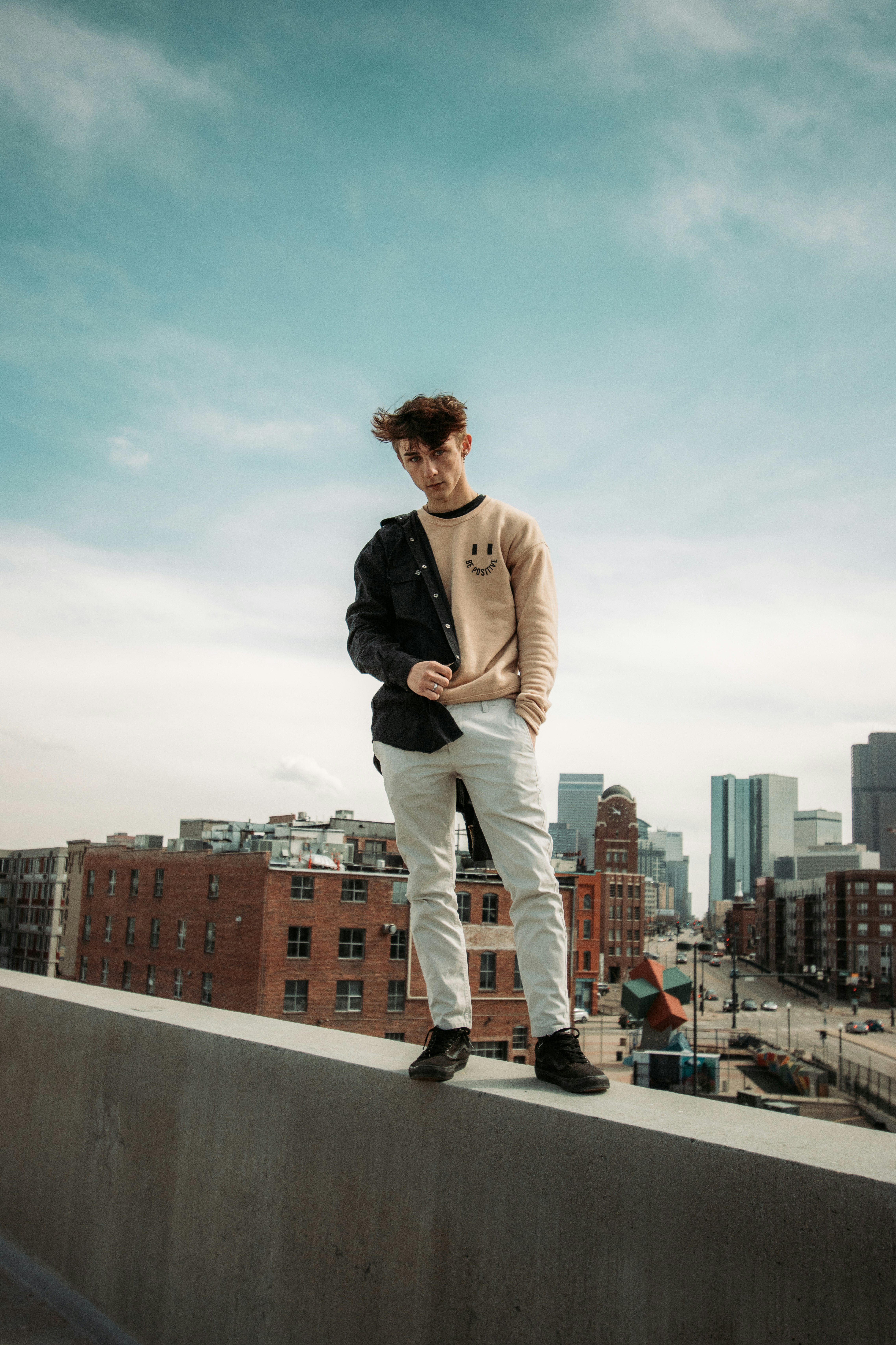 man in black jacket and beige pants standing on brown concrete floor during daytime